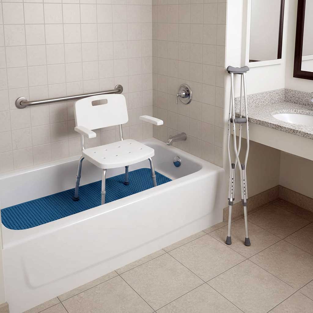 Shower chair on non-slip mat inside tub with grab bar on wall and crutches leaning against bathroom counter 3 feet away