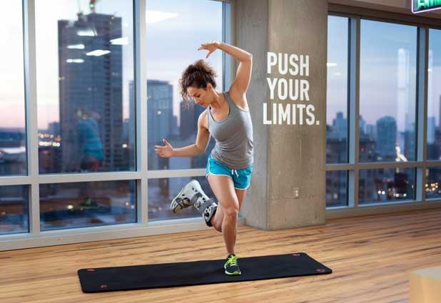 Person on crutches seated indoors using light equipment for exercises.