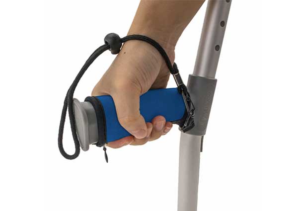 Hands gripping crutches with black neoprene grip covers