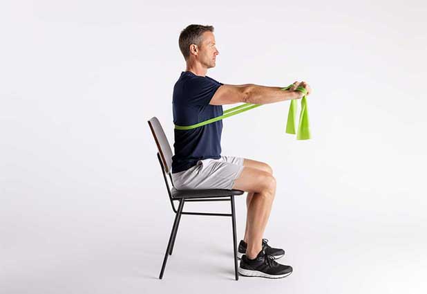 Crutch user pressing a resistance band forward while seated